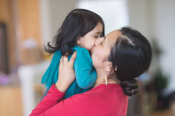 A mother kissing her child